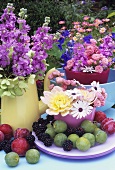 Vases of summer flowers with fruit out of doors