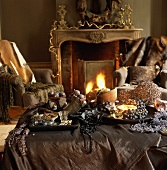 Kaminzimmer mit Sesseln & opulent dekoriertem Beistelltisch vor brennendem Kamin
