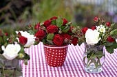 Verschiedene Rosensträusse auf Gartentisch