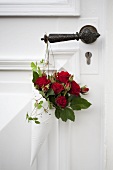 Red roses in cake paper as door decoration