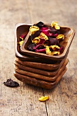 Dried rose petals in a stack of wooden bowls
