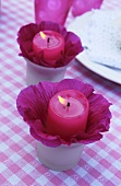 Candles in hollyhocks flowers as table decoration