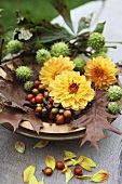 Autumnal decoration of rosehips, leaves, dahlias and chestnuts
