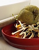 A red bowl with decorative Oriental characters, jackfruit and flowers