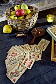 Pack of cards and basket of apples and quinces on a table