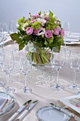 Vase of spring flowers on table laid for special occasion