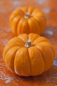 Two pumpkins on cobweb-patterned tablecloth