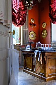 Blick durch geöffnete Tür in Innenraum mit Küchentheke im Schloss la Verrerie (Frankreich)
