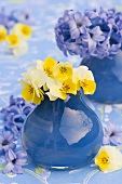Hornveilchen und Hyazinthen in blauen Vasen