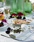 Napkin decorated with herbs & plums, plum flat cake behind