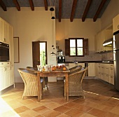 Kitchen with dining table and rattan armchairs