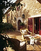 Kleiner Tisch mit Canapés und Rotwein auf Terrasse vor Landhaus