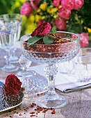 Dried rose petals and fresh rose in a glass