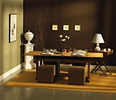 Esszimmer in Braun mit gedecktem Holztisch & Polsterhockern