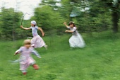 Three girls skipping through the grass