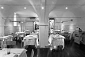A black and white photo of a designer restaurant with a vaulted ceiling and halogen lights