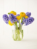 Ranunculus and hyacinths in glass vase
