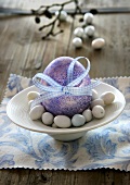Purple Easter egg with bow and sugar eggs