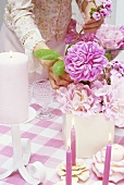 Woman arranging peonies on a dining table