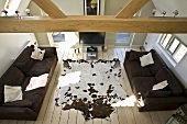Attic sitting room with couch, cowhide rug, wooden beam