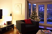 Beleuchtetes Wohnzimmer mit geschmücktem Weihnachtsbaum