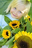 Blondes Mädchen mit Sonnenblumen