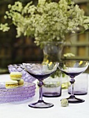 A table decorated for summer with champagne glasses, plates and macaroons