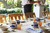 A table laid outside with a blue and white cups