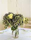 Hydrangeas and yellow roses in water