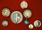 Candles with holders attached to baking tins as wall decoration