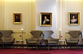Grey winged armchairs in a spacious hotel hallway a with illuminated floor lamps