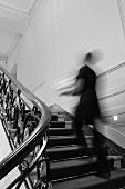 Person läuft, in einem eleganten Haus, die Treppe hinauf