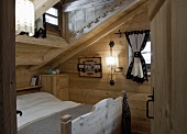 A bedroom under the roof of a wooden hut