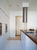 White designer kitchen - kitchen area with wooden countertop and stainless steel faucet with vent