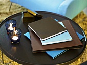 Folders and tea lights on a dark side table