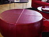 Red leather ottoman in front of side tables