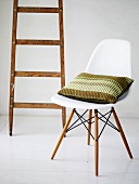 Bauhaus chair with striped pillow in front of a wooden ladder