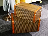 Brown luggage set with a checkerboard design on a carpet