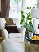 A white upholstered armchair in front of an open terrace door