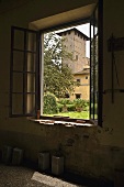 Blick durch Fenster auf italienisches Gehöft mit Turmbau