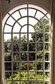 View through an arched window of a garden