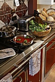 An elegant, stainless steel kitchen counter with food on the hob