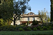 Large lawn in front of a Mediterranean villa with natural stone facade and pergola