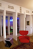 Roter gepolsterter Sessel und Beistelltisch im offenen Wohnraum