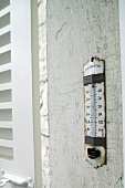 Weathered thermometer on an outside wall