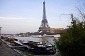 Sunny day in Paris - house boat docked on the bank looking across the Seine at the Eiffel tower