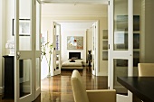 A suite of rooms - open glass doors and continuous parquet floor in a dining room and a living room