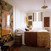 Moderner Wandteppich vor weiss vertäfelter Wand mit Doppelbett und Fenster mit innenseitigen Läden