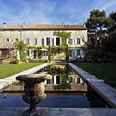 A house in Provence and antique Greek urns by a pool in the garden