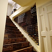 A flight of old wooden stairs and a wine storage area in a niche